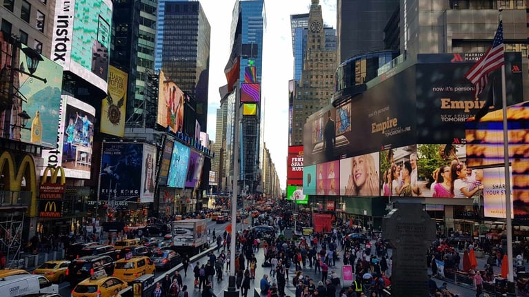  A busy city center full of digital billboards and advertisements, demonstrating the reach of digital out-of-home (DOOH) marketing.